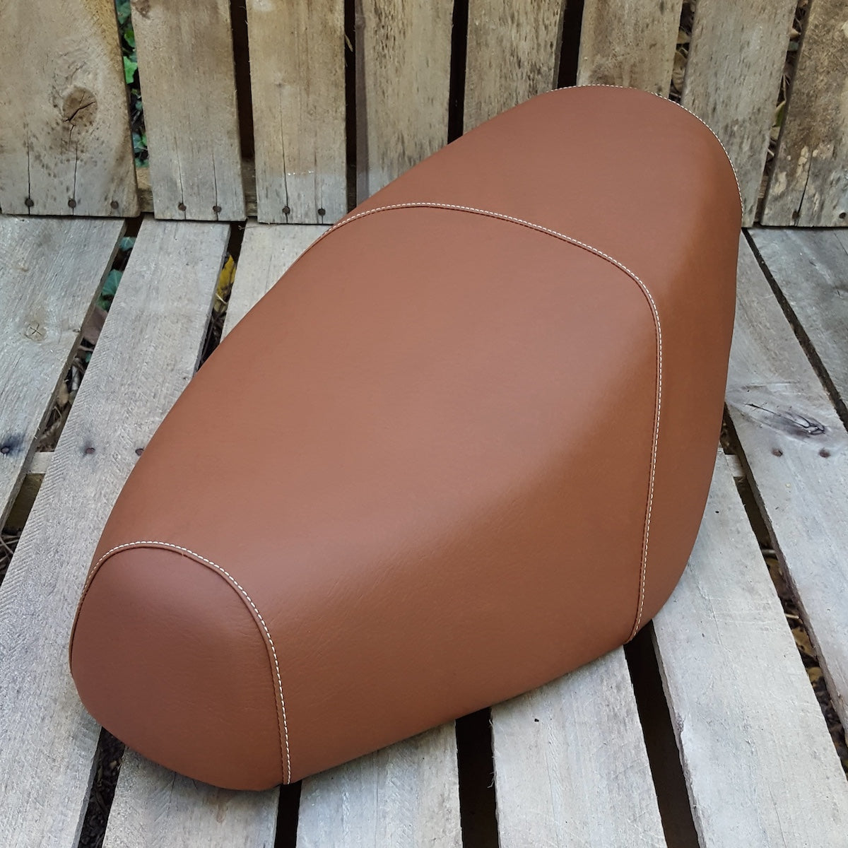 Cinnamon-brown Cheeky Seats cover for a Genuine Buddy standard seat with cream topstitching