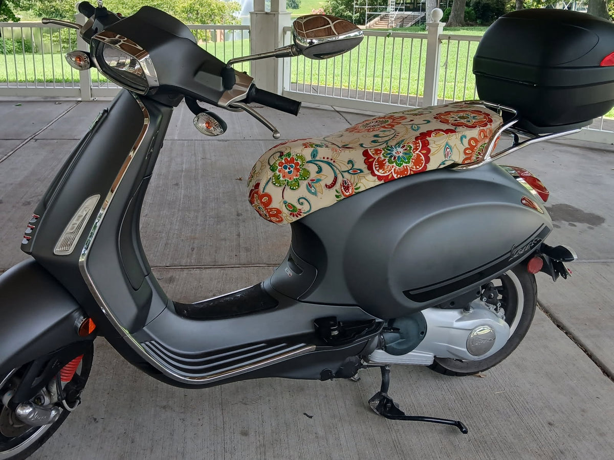 Ecru Floral seat cover fitted to a matte gray Vespa, showing the tailored shape and distinctive medallion pattern, handmade by Cheeky Seats.