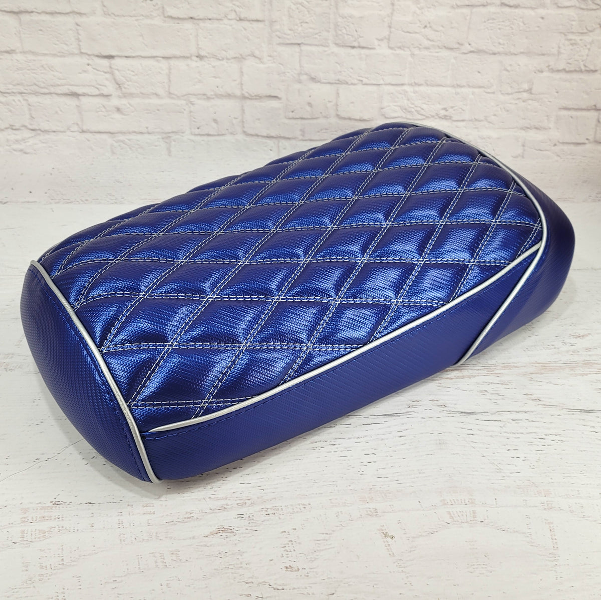 Metallic blue diamond-stitched Maddog seat cover with white stitching, white piping, and matching blue side panels, handmade by Cheeky Seats