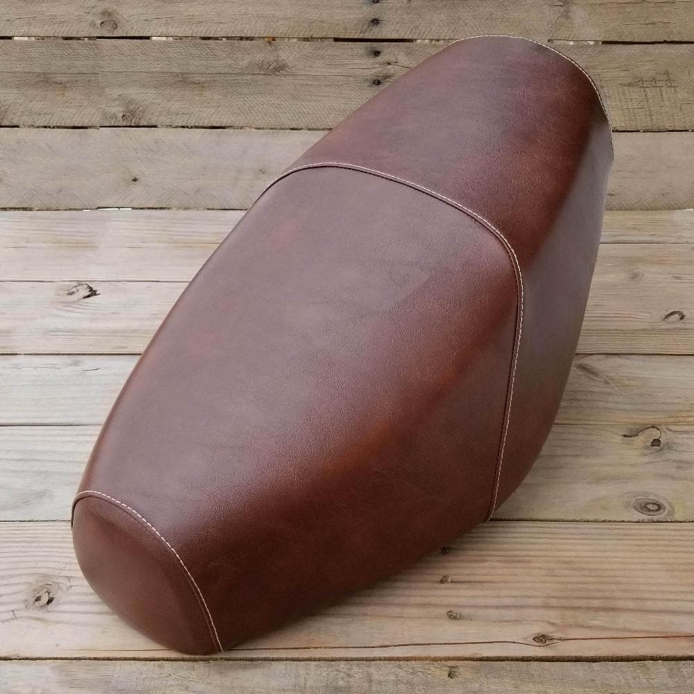Distressed whiskey-brown Cheeky Seats cover for a Genuine Buddy standard seat, front studio view