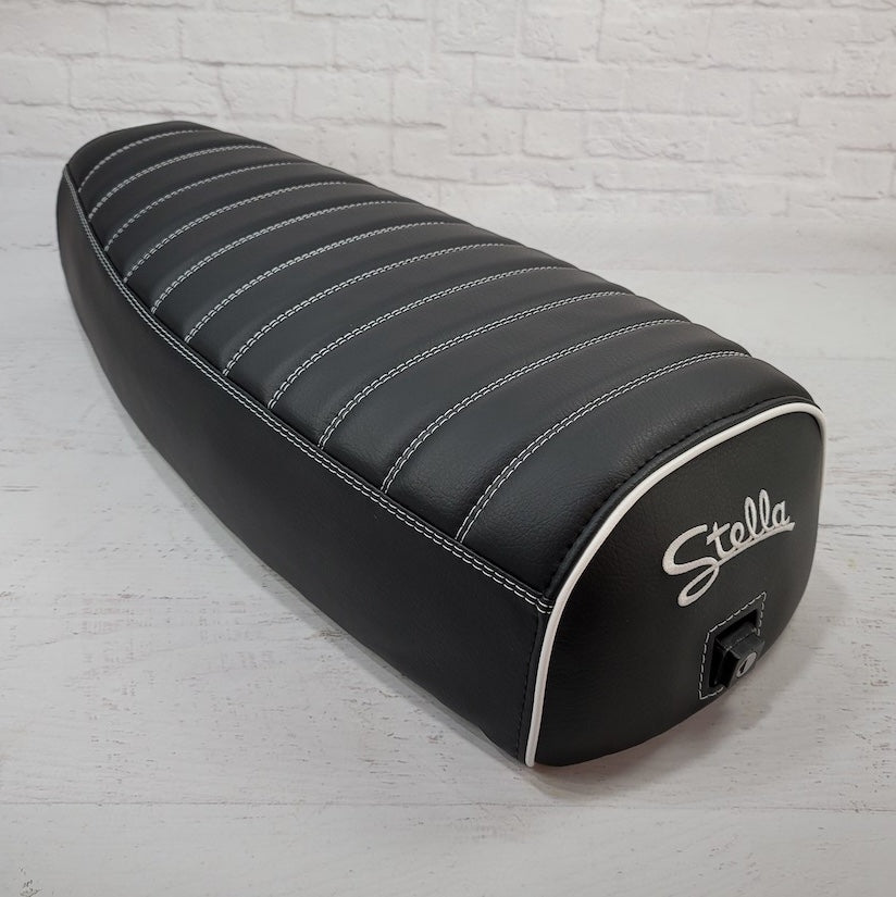 Rear angle of a black Genuine Stella tuck-and-roll cover with white piping and embroidered Stella logo, handmade by Cheeky Seats
