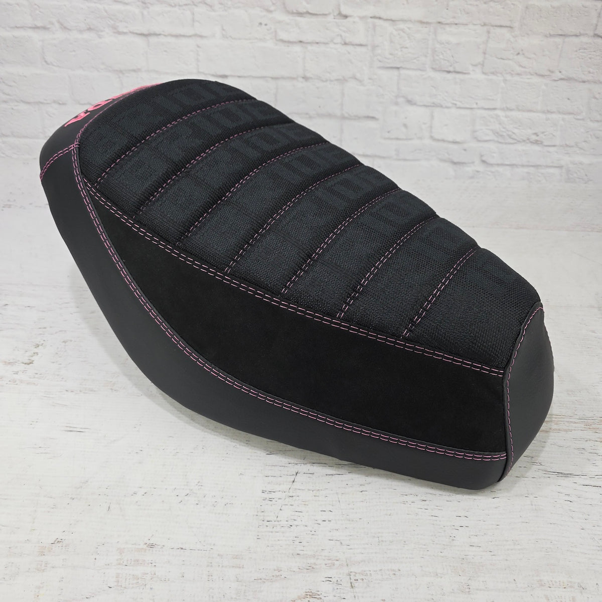 front view Honda Dio 1 & 2 Seat cover with Black Bride deck, Alcantara sides and matte black, trimmed with pink stitching and a pink Honda logo.  Handmade by Cheeky Seats