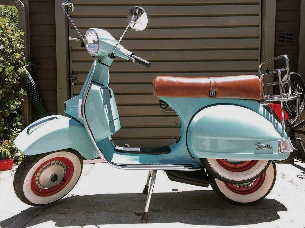 Pale blue Genuine Stella with a whiskey-brown seat cover handmade by Cheeky Seats, shown in profile