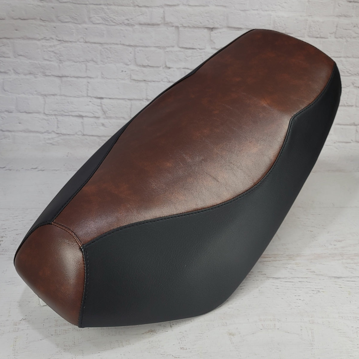 Brown and Black Yamaha Zuma 50 seat cover with a smooth vintage-brown center and tailored black side panels, handmade by Cheeky Seats.