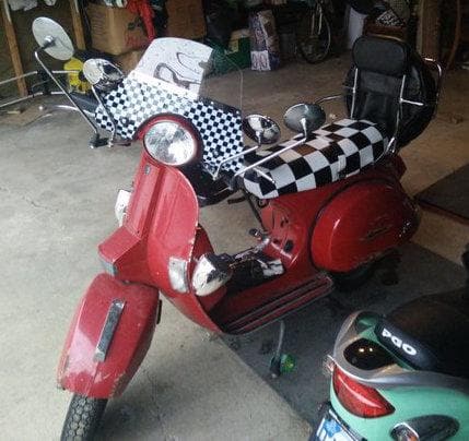 Red Genuine Stella with a black-and-white checker seat cover handmade by Cheeky Seats