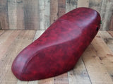 Low front view of an oxblood Piaggio Fly 50–150 cover with tonal French seams and side lock opening, handmade by Cheeky Seats