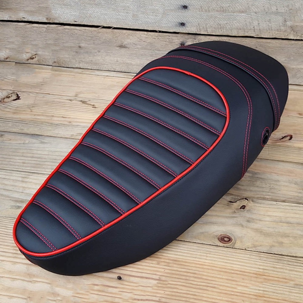 Black Vespa S padded tuck-and-roll seat cover with red piping and stitching, handmade by Cheeky Seats